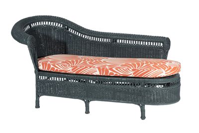 an image of a black wicker daybed with an orange and white cushion
