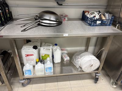 une table en acier inoxydable sur laquelle est posée une casserole