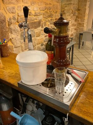 pots and pans sit on a kitchen counter with a stone wall
