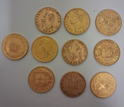 six types différents de pièces d'or sur une surface blanche