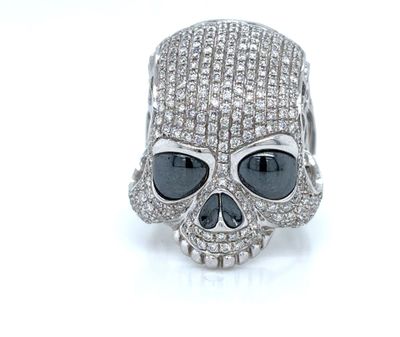 silver skull ring with black and white stones on it