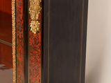 a black and gold cabinet with a glass door