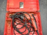 an electric drill in a red case with a cord in it