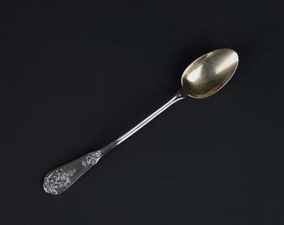 a silver spoon with a spoon handle on a black surface
