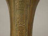 a gold vase that has a design on it