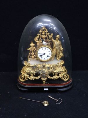 a gold clock under a glass dome on a black surface