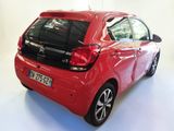a red car that is parked in a white room