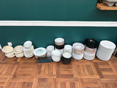 many plates and bowls lined up on the floor
