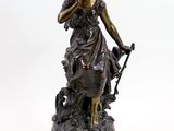 statue en bronze représentant une femme accompagnée d'un chien, posée sur un socle en marbre