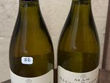 two bottles of wine sitting on top of a wooden table