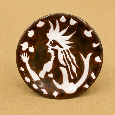 une assiette marron et blanche sur laquelle est représentée une femme