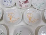 many plates with drawings on them on a table