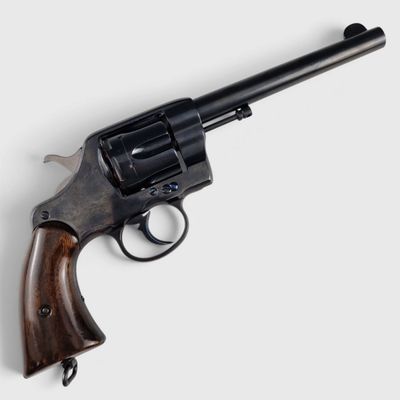 un vieux revolver avec un manche en bois sur fond blanc