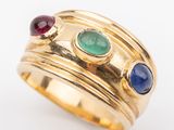 an image of a gold ring with three different colored stones