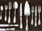 a set of silverware on a brown table cloth