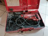 a tool in a red case sitting on a tiled floor