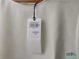 the back of a white top with a price tag on it