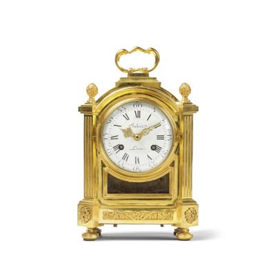 une horloge dorée avec un cadran blanc sur fond blanc
