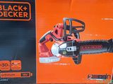 La tronçonneuse électrique Black & Decker se trouve dans la boîte posée par terre.