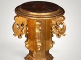 a gold pedestal with a marble top on a white background