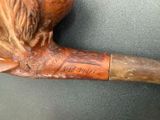 a wooden pipe with a carving of a man ' s head on it