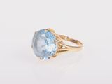 une bague en or sertie d'une topaze bleue au centre
