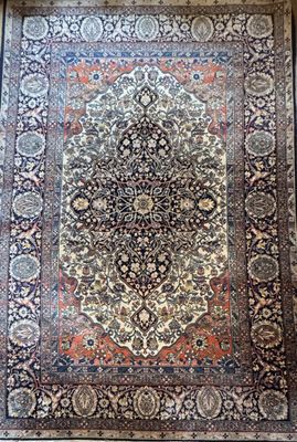 an antique persian rug with a medallion design on a wooden floor