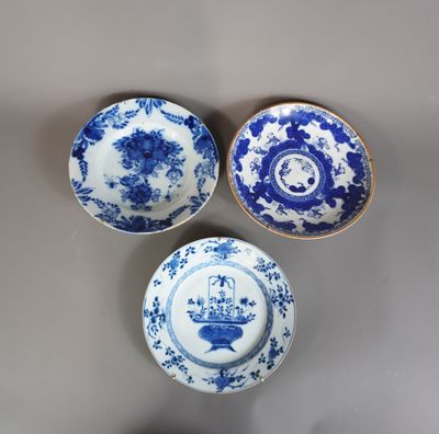 trois assiettes bleues et blanches à motifs posées sur une table