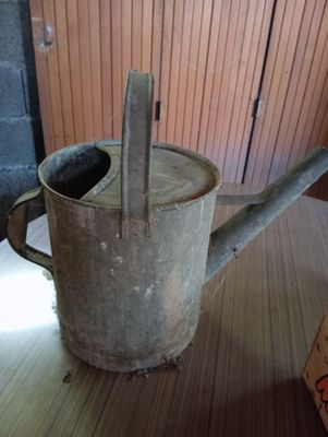 un petit arrosoir posé sur une table à côté d'une boîte