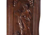 a carved wood plaque depicting a woman holding a child