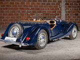 an image of a vintage car parked in front of a brick wall