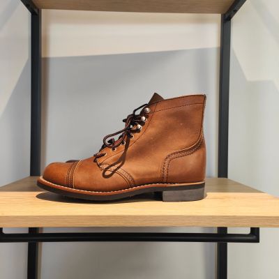 des bottes en cuir marron posées sur une étagère dans un magasin de chaussures