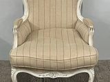 beige and white striped upholstered chair on carpeted floor