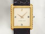 a gold watch with roman numerals on the face