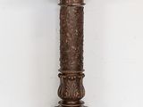an image of a tall wooden pedestal with carvings on it