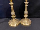 pair of antique brass candlesticks on a black background