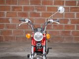 a red motorcycle parked in front of a brick wall