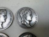 three silver coins with heads of women on them sitting on a table