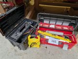 une boîte à outils rouge contenant des outils, posée par terre