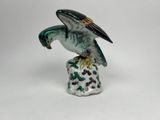a figurine of a bird that is sitting on top of a rock
