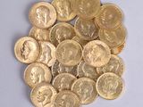 a pile of gold coins sitting on a white surface