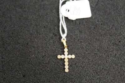 a cross necklace with a tag attached to it on a black surface