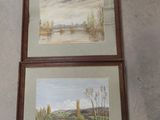 two framed paintings of a river and a landscape on a wall