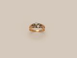 a close up of a ring with two pearls on it
