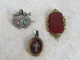 three pieces of jewelry sitting on top of a white surface