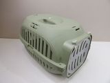 a small green dog carrier on a white table