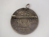a silver coin with a bar in the middle of it