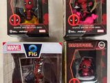 un lot de quatre figurines Deadpool dans leurs boîtes, posées sur une table