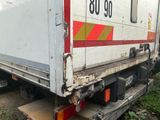 un camion blanc orné d'une bande rouge, garé sur le bord de la route