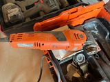 an orange corded drill in a case with tools in it